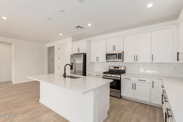 a kitchen with kitchen island a sink stove and refrigerator