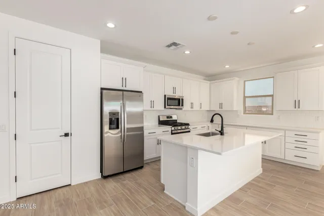 a kitchen with refrigerator cabinets and wooden floor