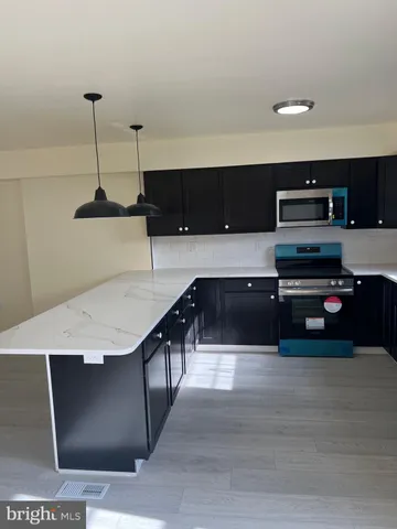 a living room with stainless steel appliances kitchen island granite countertop a refrigerator a stove a sink and dishwasher