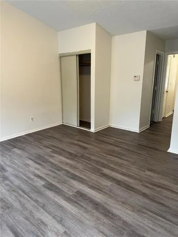 a view of a hallway with wooden floor and a room