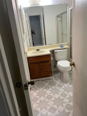 a bathroom with a toilet sink and mirror