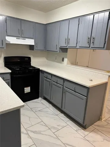 a kitchen with a sink dishwasher a stove top oven a refrigerator and cabinets