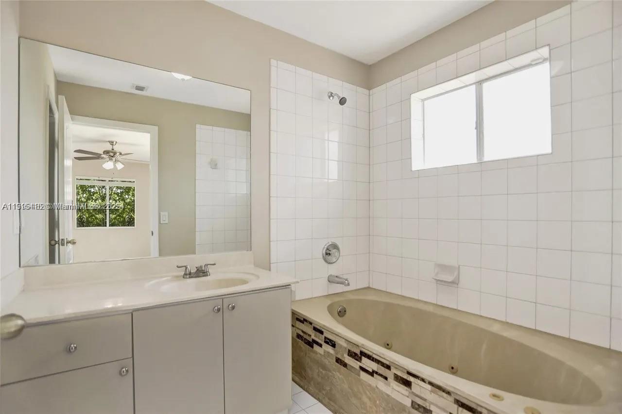 2802 Southwest 128th Way Miramar, FL 33027 - Photo 31 of 37 a bathroom with a tub a sink and a window