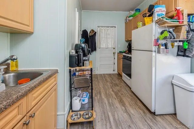 a kitchen with a refrigerator and a wooden floor
