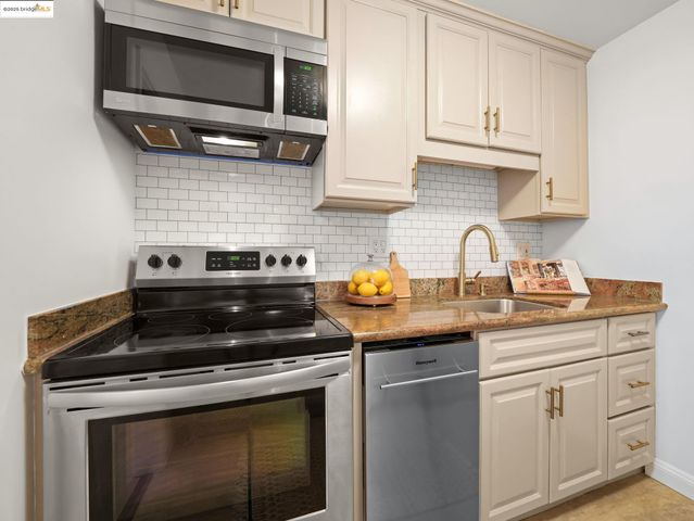 a kitchen with appliances a sink and cabinets