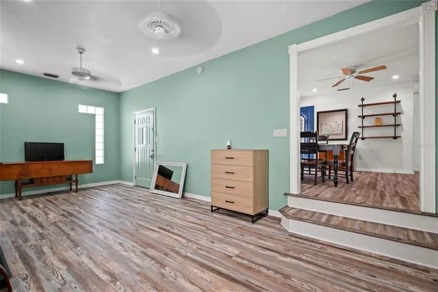 a living room with furniture and a wooden floor