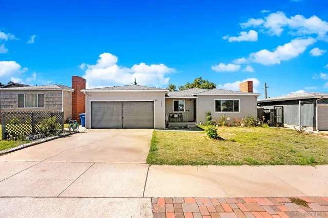 a front view of a house with a yard and potted plants