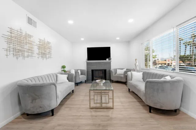 a living room with furniture a fireplace and a flat screen tv