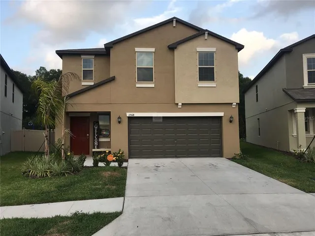 a front view of a house with a yard and garage