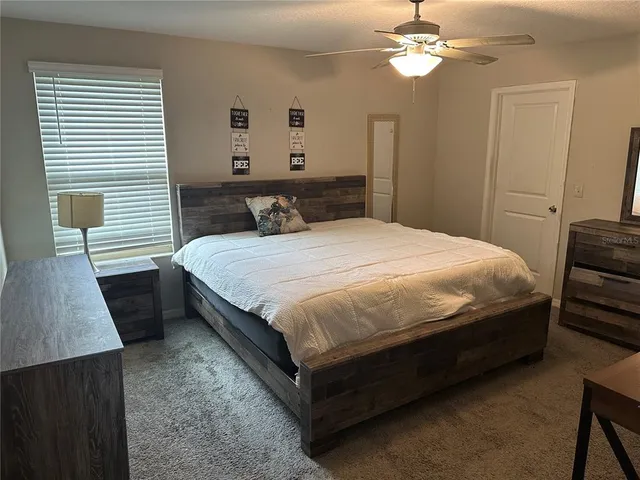 a bedroom with a bed lamp and a dresser
