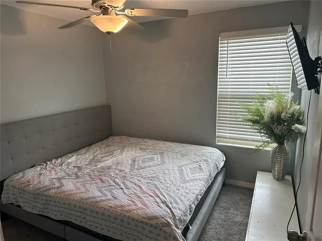 a bedroom with a bed and a potted plant
