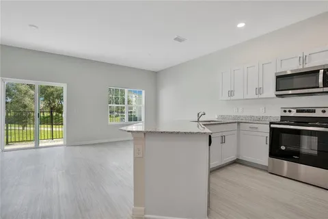 a kitchen with a sink a microwave and cabinets