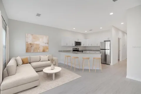 a living room with furniture and a view of kitchen