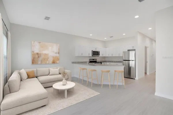 a living room with furniture and a view of kitchen