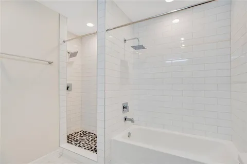 a bathroom with a shower and a bath tub