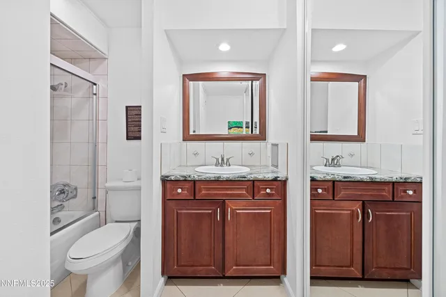 a bathroom with a granite countertop toilet sink and mirror