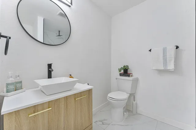 a bathroom with a sink a toilet and a mirror