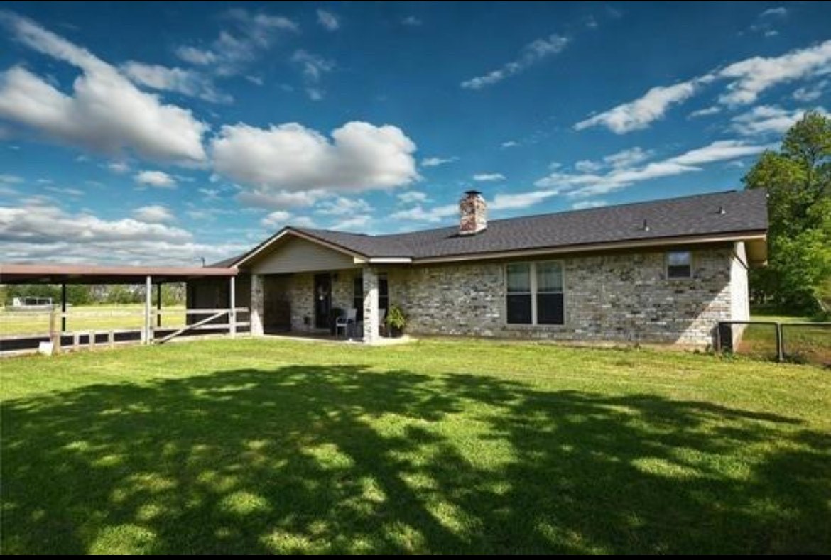 a front view of a house with a garden and trees