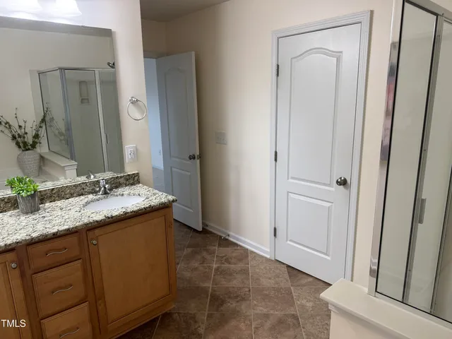a bathroom with a granite countertop sink and a mirror