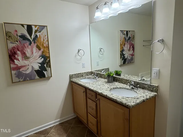 a bathroom with a granite countertop sink a mirror and a picture