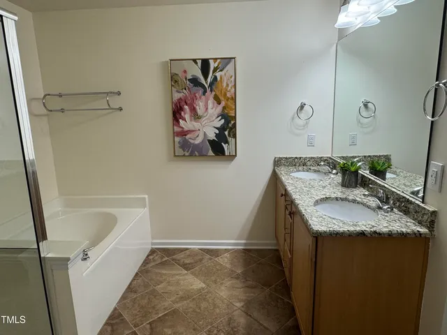 a bathroom with a granite countertop sink a mirror and a shower