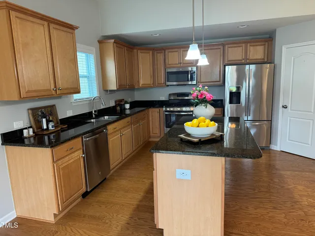 a kitchen with stainless steel appliances granite countertop a sink refrigerator and microwave