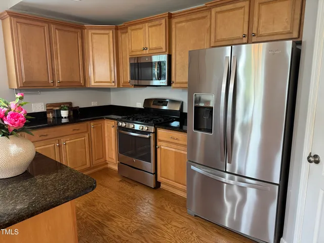 a kitchen with stainless steel appliances granite countertop a refrigerator sink and stove