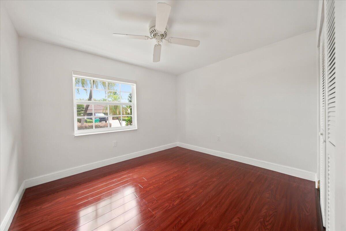 20009 Northwest 66th Place Hialeah, FL 33015 - Photo 27 of 33 an empty room with wooden floor chandelier fan and windows