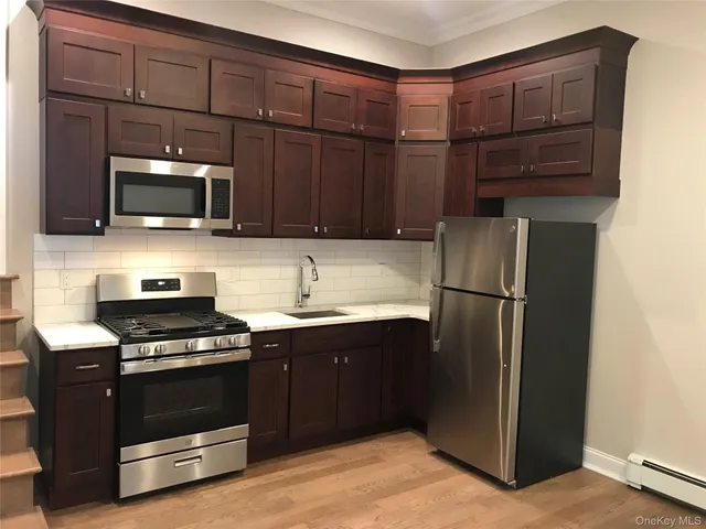 a kitchen with granite countertop a refrigerator and a stove top oven