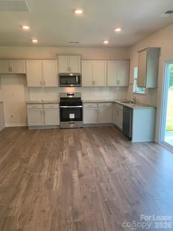 a kitchen with granite countertop white cabinets and stainless steel appliances