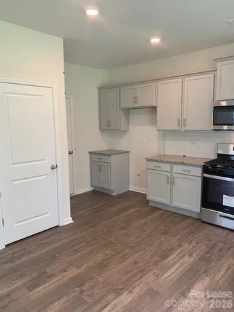 a view of kitchen with wooden floor and electronic appliances