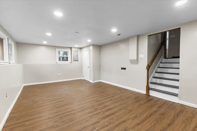 a view of empty room with wooden floor and window