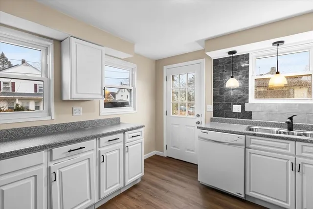 a kitchen with white cabinets and sink