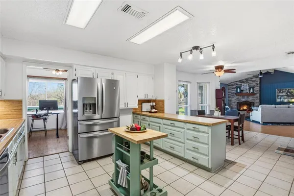 a kitchen with stainless steel appliances kitchen island granite countertop a stove a sink and a refrigerator