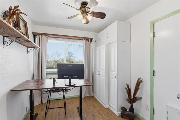 a view of a workspace with furniture and a window