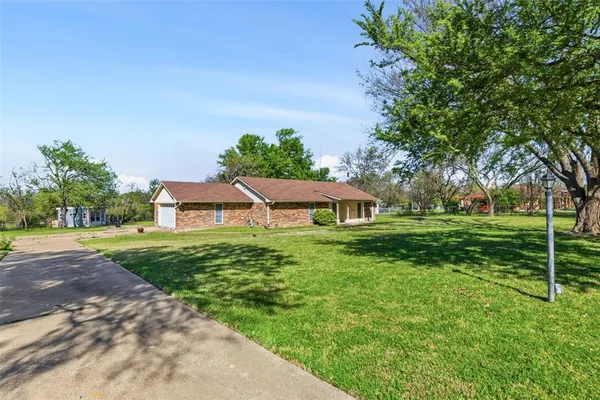 a front view of a house with a yard and trees