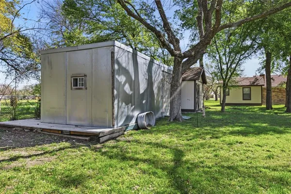 a view of a house with backyard and a tree