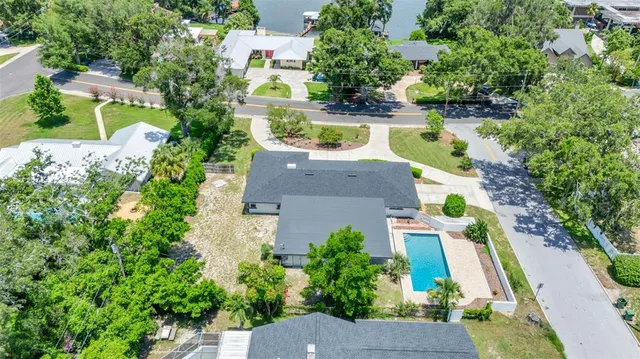 an aerial view of a houses with a yard and lake view
