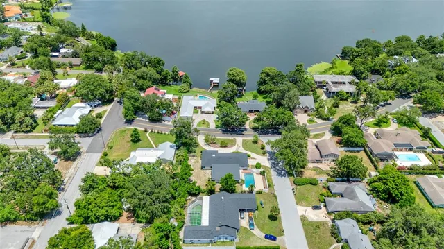an aerial view of residential houses with outdoor space and trees