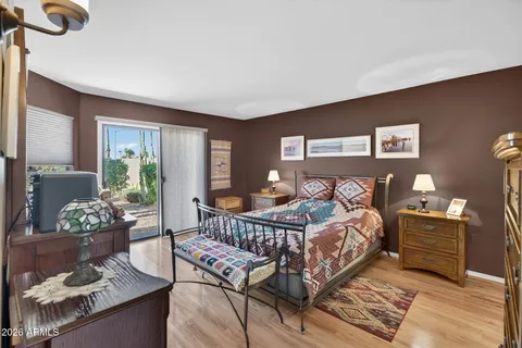 a bedroom with a bed and wooden floor