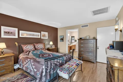 a bedroom with a bed and wooden floor