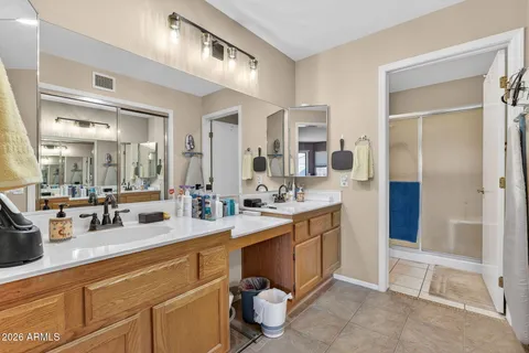 a large white kitchen with a sink and a large mirror