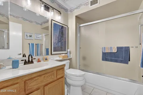 a bathroom with a sink a toilet a mirror a vanity and shower