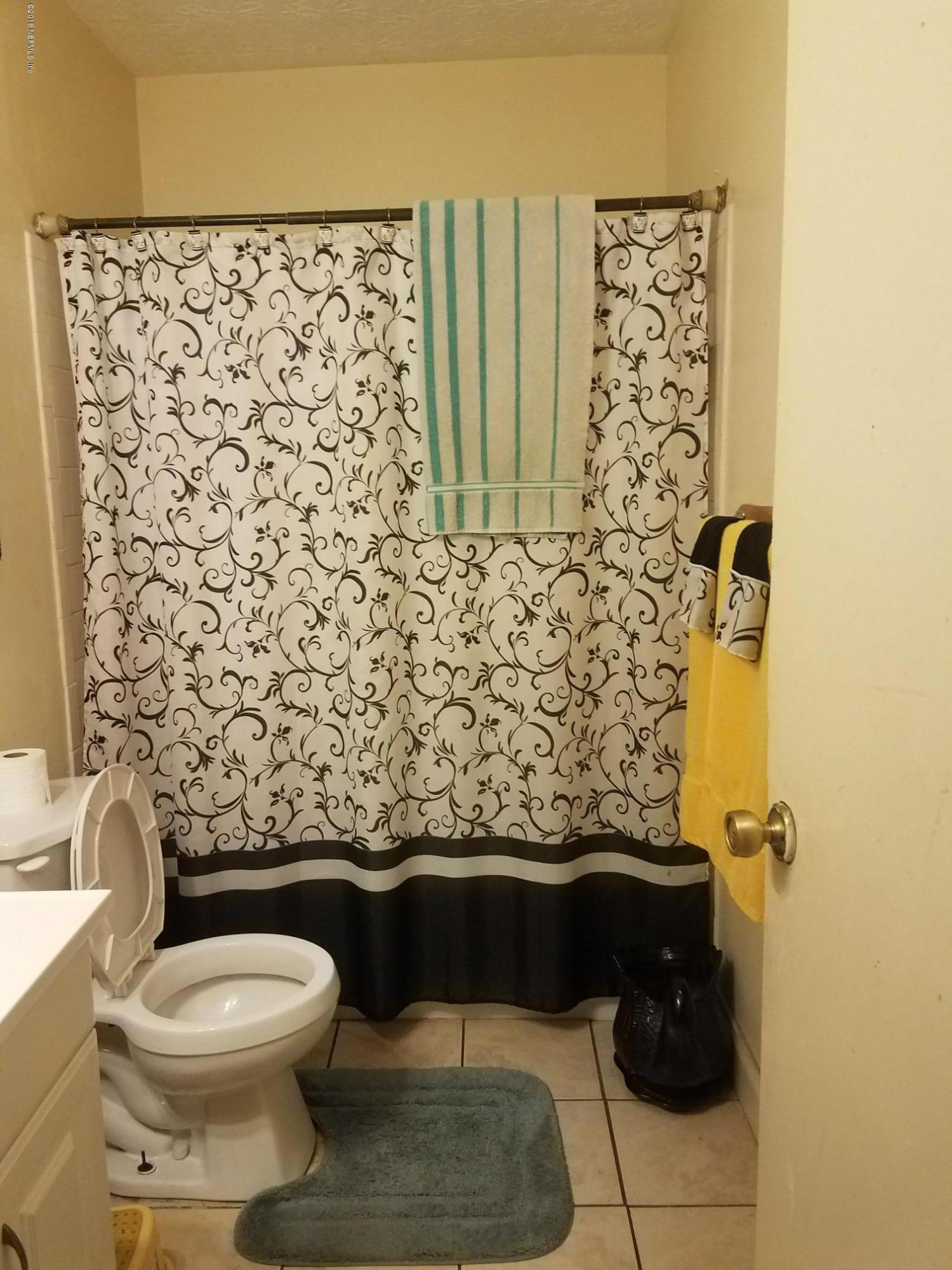 2412 Automobile Drive Jacksonville, FL 32209 - Photo 4 of 10 a bathroom with a toilet and a shower curtain