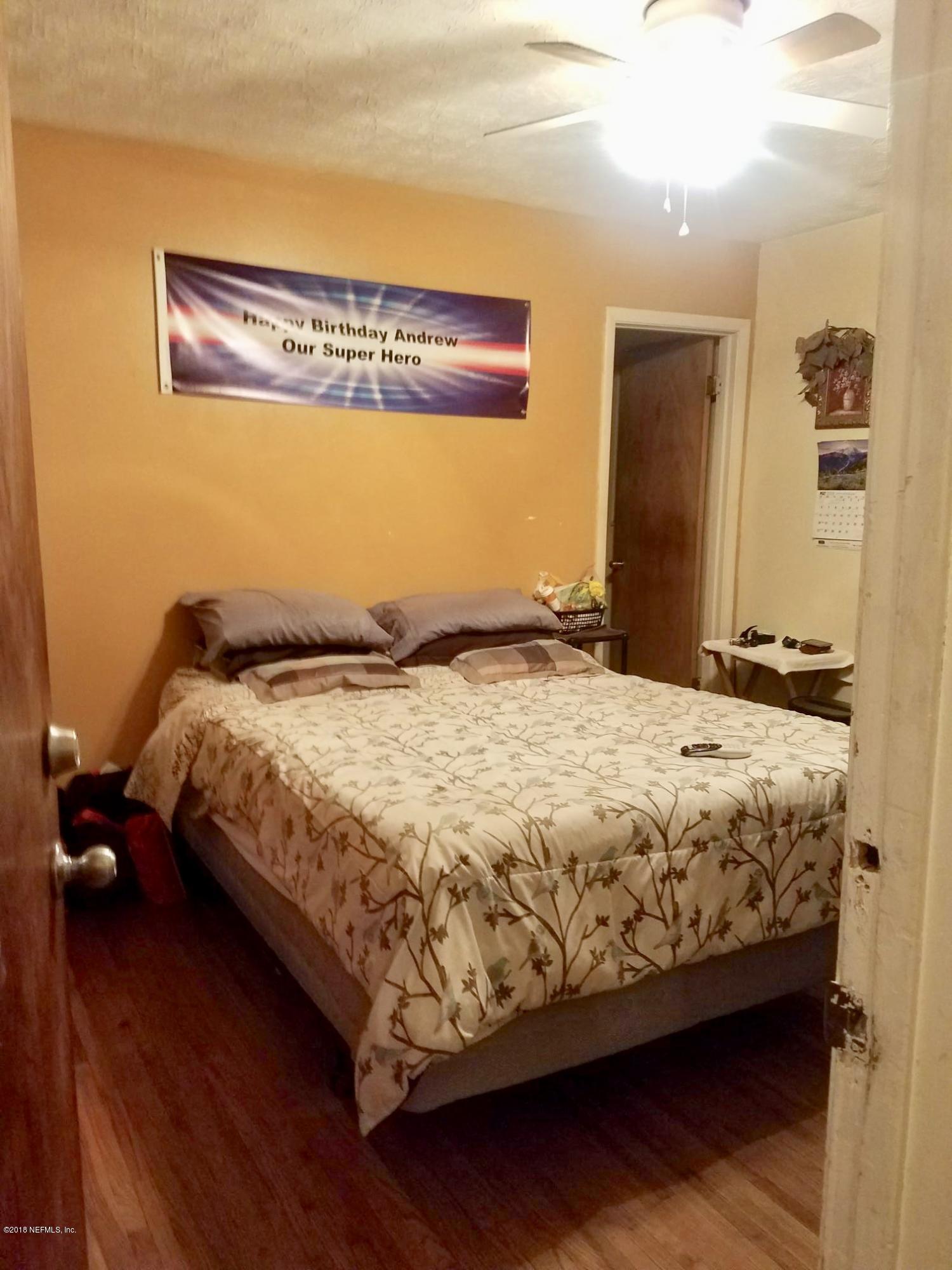 2412 Automobile Drive Jacksonville, FL 32209 - Photo 7 of 10 a bed sitting in a bedroom next to a bathroom