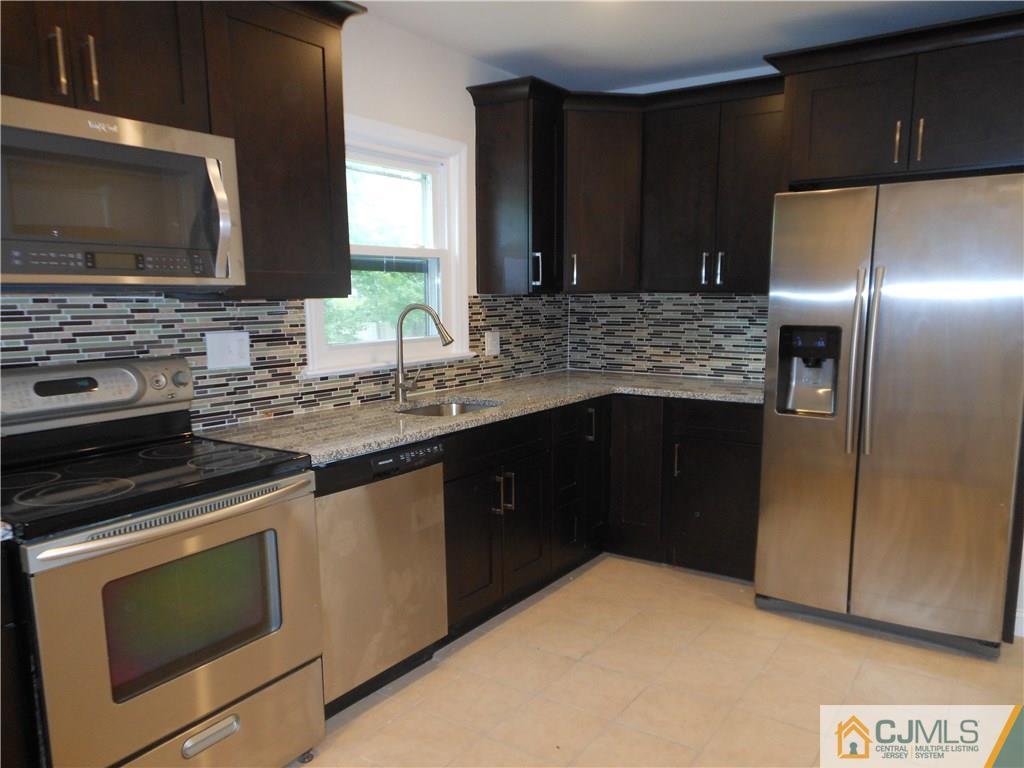 161 Jordan Road Colonia, NJ 07067 - Photo 4 of 15 a kitchen with stainless steel appliances granite countertop a stove a microwave and a refrigerator