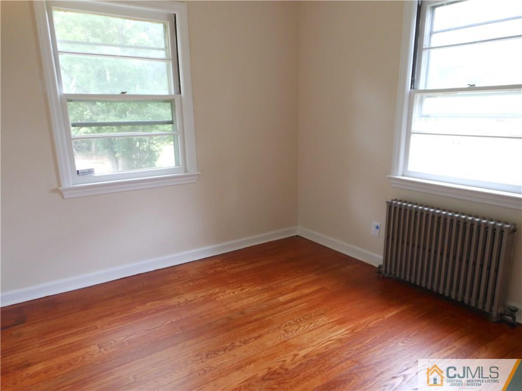 161 Jordan Road Colonia, NJ 07067 - Photo 8 of 15 an empty room with wooden floor and windows