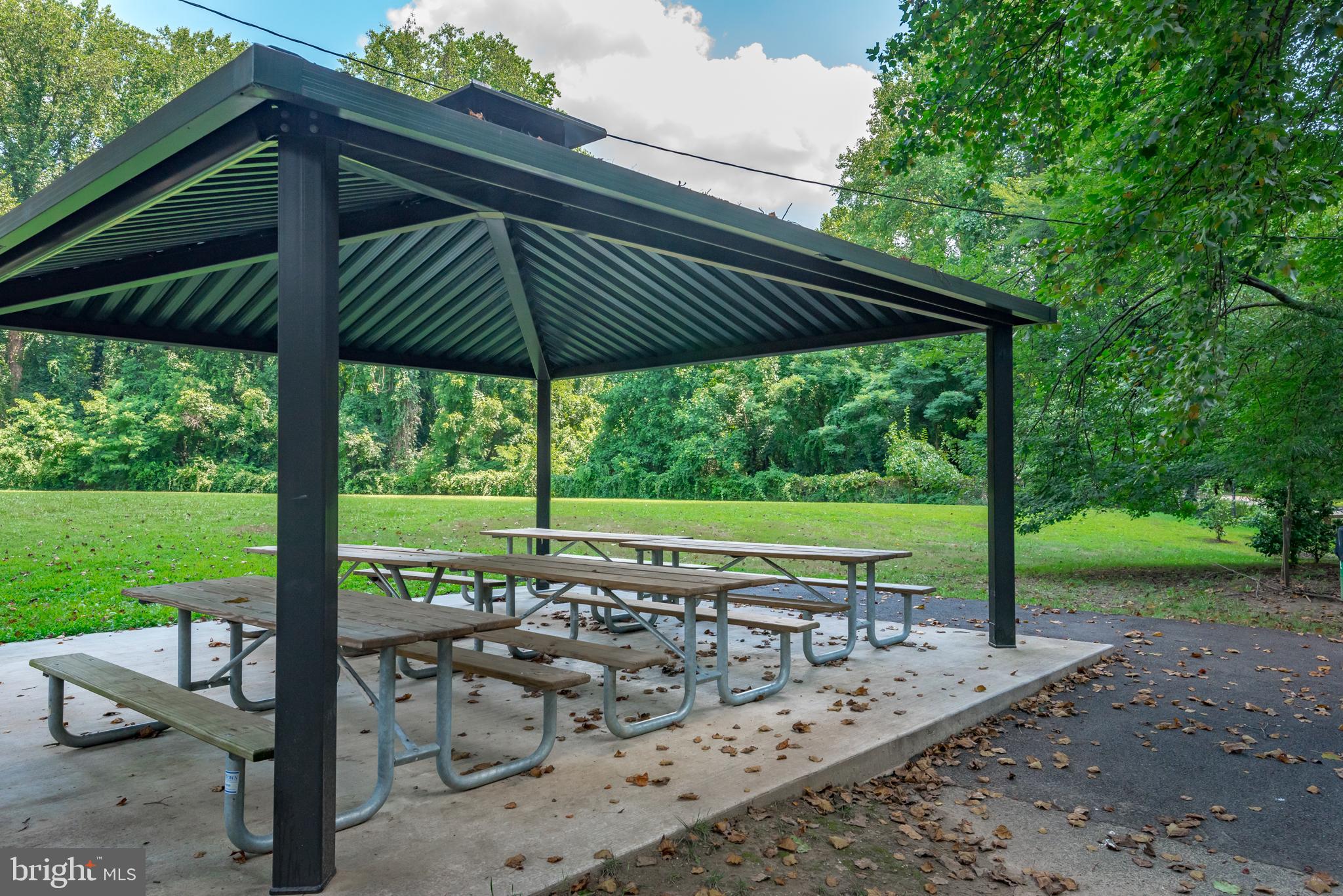 902 Hine Trail Crownsville, MD 21032 - Photo 14 of 28 a view of a patio with table and chairs under an umbrella with a large tree