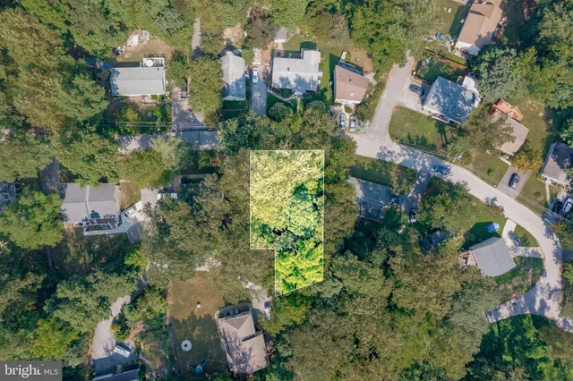 an aerial view of residential house with outdoor space and trees all around