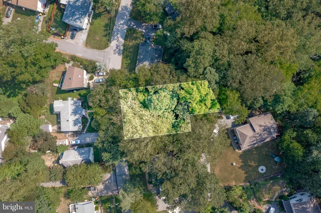an aerial view of residential house with outdoor space and trees all around
